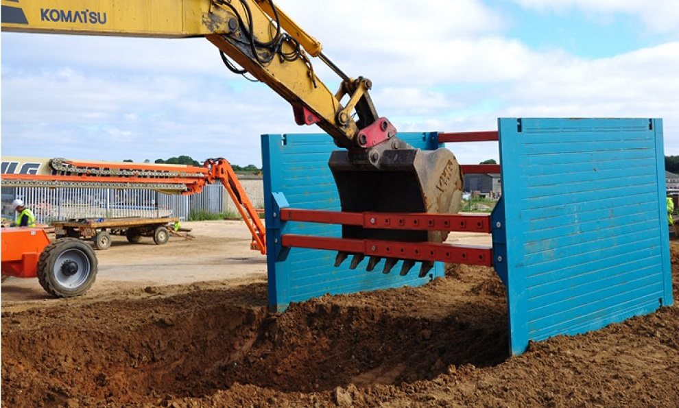 A Drag Box being pulled i.e dragged and cutting into the ground using an excavator